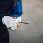 Close-up of hands checking engine oil level with a dipstick